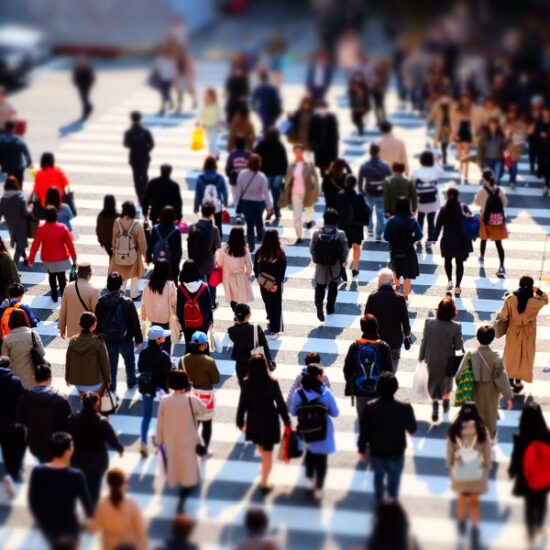A busy pedestrian crossing with many people crossing